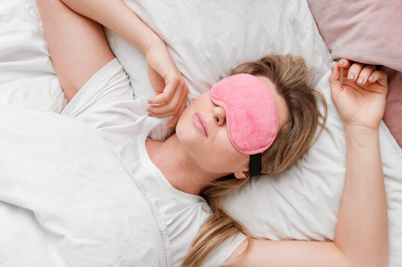 žena s blond vlasmi s ružovou maskou na spanie