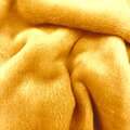 Hrejivá deka z jemných počesaných priadzí v medovej farbe. 