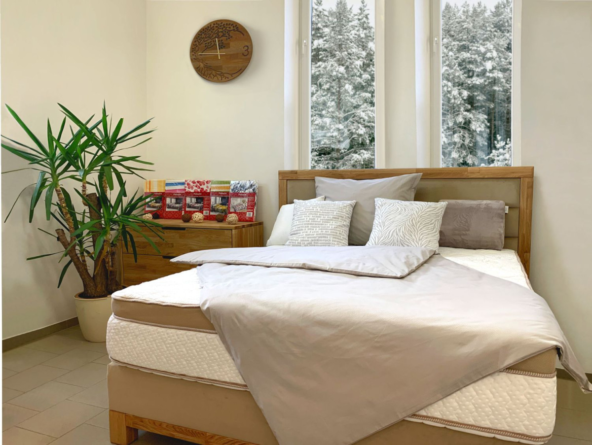 boxspringová posteľ s makodamaškovými obliečkami v krémovej farbe