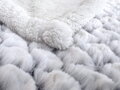 Baránková deka v jemnej bielej farbe so šupinkovým vzorom a zadnou sneho-bielou stranou z mäkučkého materiálu.