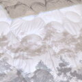 Extra hrejivá deka z jemného plyšu v šedo-hnedej farbe s potlačou maľovaných stromov.
