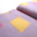 Hravá detská deka s farebnými štvorcami na fialovom podklade.