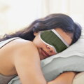 Maska na spanie s jemným povrchom z bavlneného damašku zelenej farby.