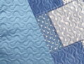 Obojstranne potlačený prehoz v modrastých tónoch s potlačou dizajnu patchwork. 