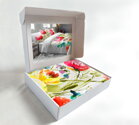 Farebné makosaténové obliečky SORYA s rozkvitnutými kvetinami v darčekovej krabičke.